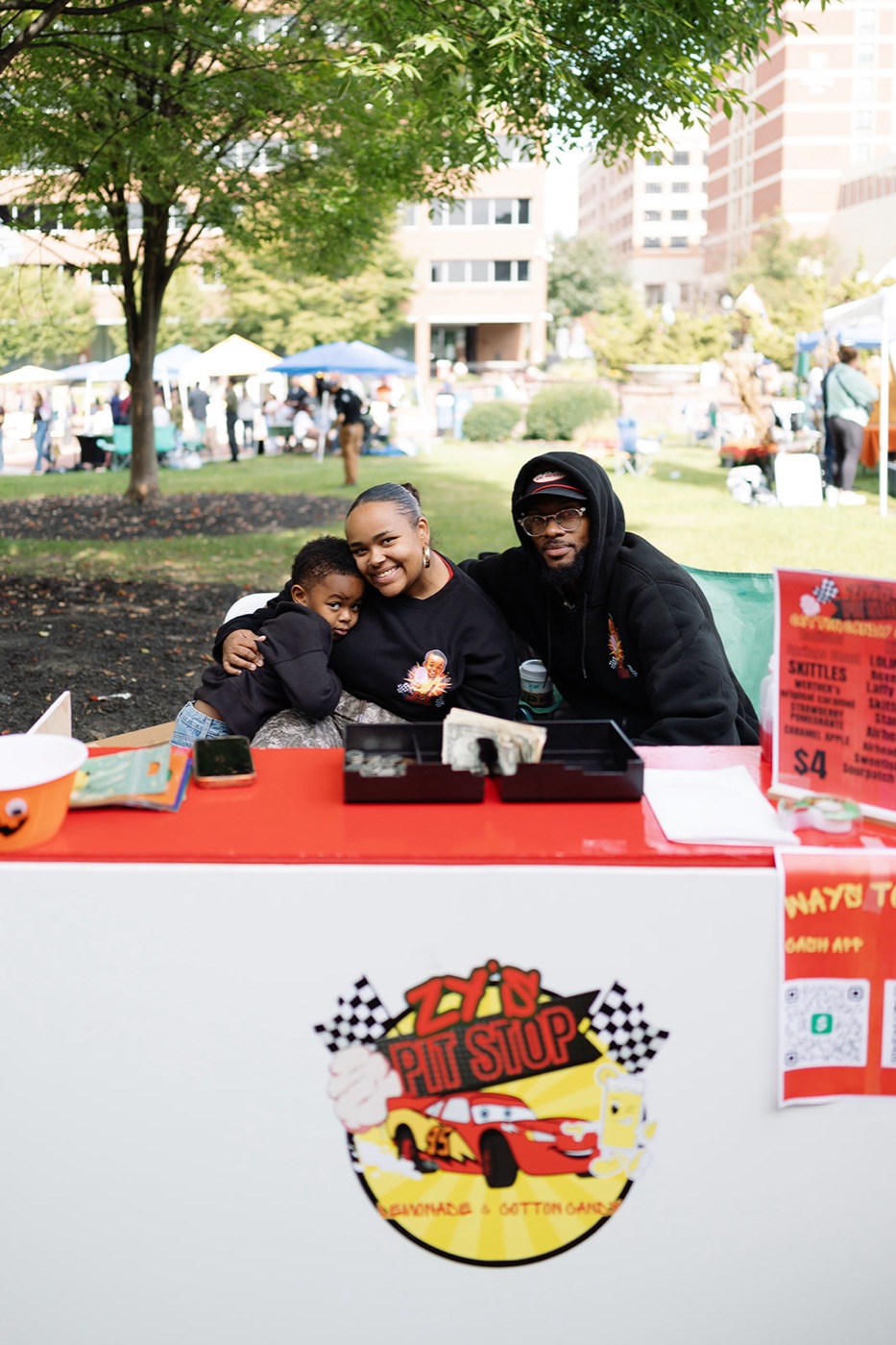 A family behind the Zy's Pit Stop lemonade and cotton candy stand